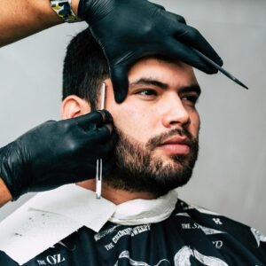 Man receiving a precise beard trim in a barbershop, showcasing expert grooming skills.